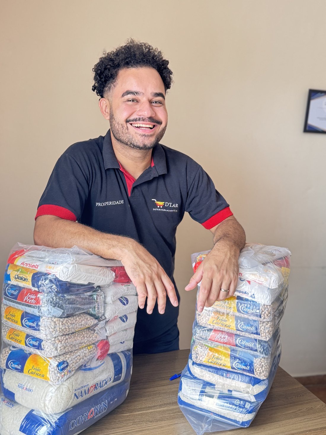 Atendente da D'LAR com kits de cestas básicas montados
