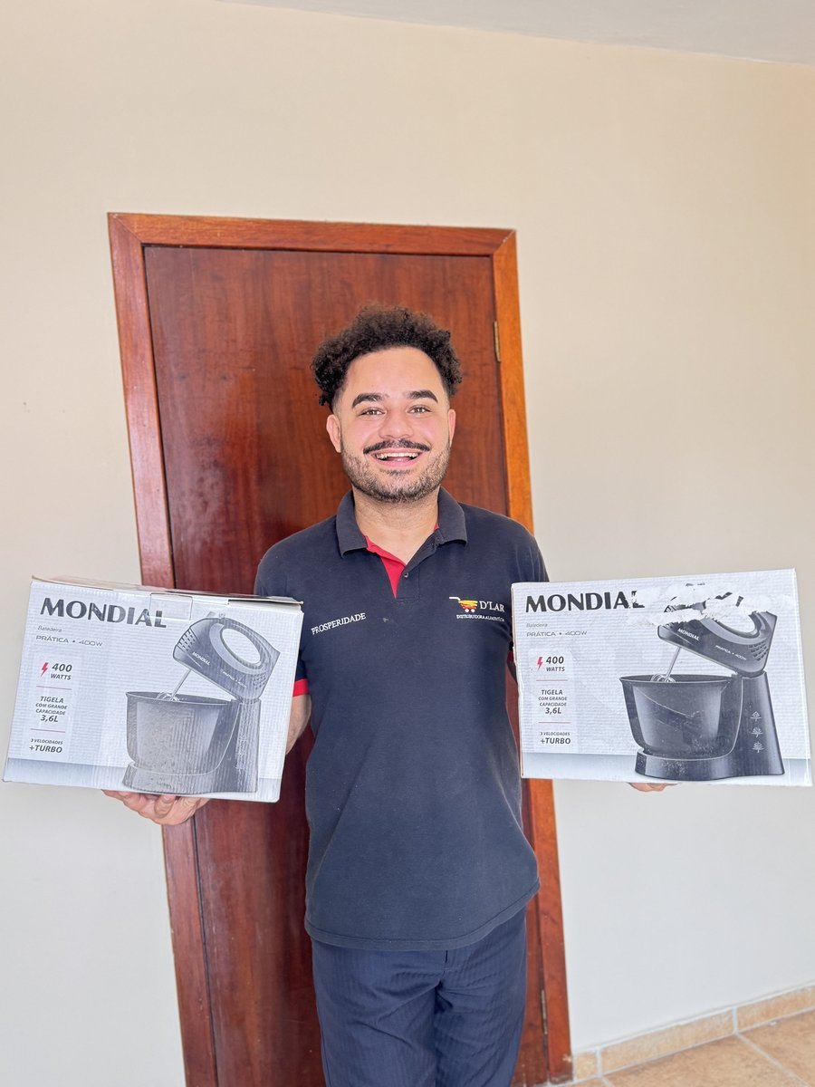 Atendente da D'LAR mostrando as batedeiras do sorteio mensal